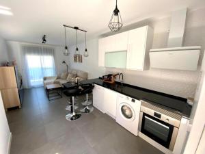 - une cuisine avec lave-linge et sèche-linge dans la chambre dans l'établissement NEREA Rota Apartment by Cadiz4Rentals, à Rota