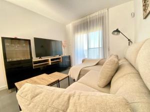 Il comprend un salon doté d'un canapé et d'une télévision à écran plat. dans l'établissement NEREA Rota Apartment by Cadiz4Rentals, à Rota