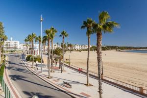 une rue avec des palmiers et une plage dans l'établissement NEREA Rota Apartment by Cadiz4Rentals, à Rota