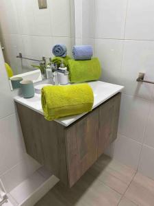 a bathroom with a sink with a yellow towel on it at Departamento Zurich en Temuco in Temuco