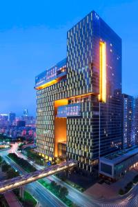 een hoog gebouw met een snelweg ervoor bij W Guangzhou in Guangzhou