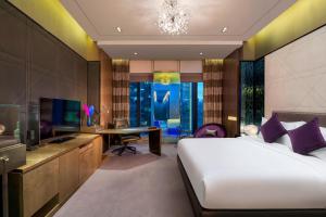 廣州的住宿－W Guangzhou，一间卧室配有一张床、一张书桌和一台电视
