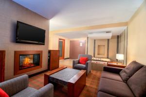 a living room with a couch and a fireplace at Four Points by Sheraton Winnipeg South in Winnipeg