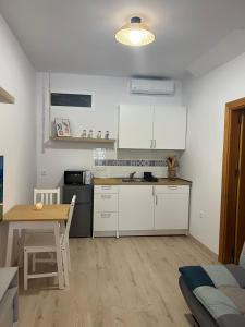 a kitchen with white cabinets and a table in a room at La casa de Lola in Caleta De Velez