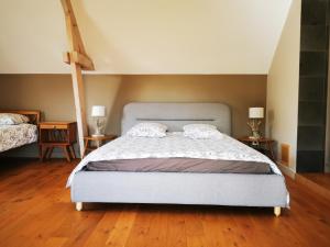 ein Schlafzimmer mit einem großen Bett und zwei Nachttischen in der Unterkunft La Chouette - Les Bastides d'Edouard - Bourgogne in Mailly-le-Château