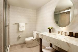 a bathroom with a toilet and a sink and a mirror at Viewline Resort Snowmass, Autograph Collection in Snowmass Village