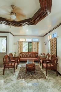 a living room with couches and chairs and a table at Casa Ella in General Luna