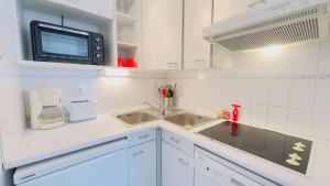 サン・マルタン・ド・レにあるJoli appartement proche du port de Saint Martinのシンクと電子レンジ付きのキッチン