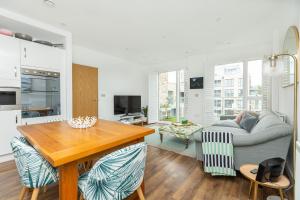 a kitchen and living room with a table and a couch at Stunning 1BR Flat in Hackney, 2 min London Fields in London