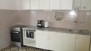 una cucina con mobili bianchi e un forno a piano cottura di Apartments Aba a Hvar