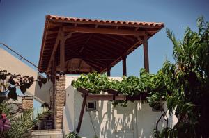 a wooden pergola on the side of a house at Panorama Studios in Kefalos