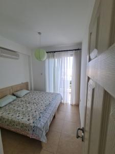a bedroom with a bed and a window at Penthouse with rooftop terrace in Akanthou
