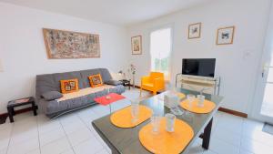 サン・マルタン・ド・レにあるJoli appartement proche du port de Saint Martinのソファとテーブルのあるリビングルーム +2枚の写真