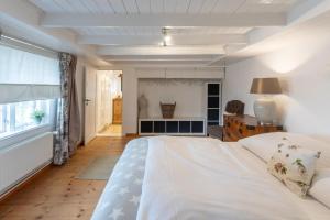 Un dormitorio con una gran cama blanca y una ventana en Das Countryhouse, en Humptrup