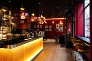 um bar num restaurante com paredes e cadeiras vermelhas em Marmont Hotel em Genebra