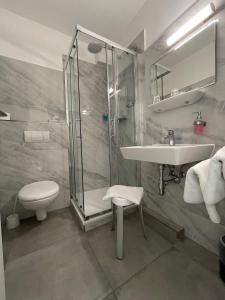uma casa de banho com um chuveiro, um lavatório e um WC. em Hotel Rosenheim em Schwentinental