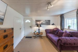 sala de estar con sofá púrpura y mesa en Das Countryhouse, en Humptrup