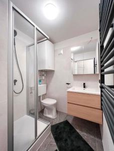 a bathroom with a shower and a toilet and a sink at Das Hirscherl - Mountain Design Studio in Bad Kleinkirchheim