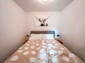a bedroom with a bed with a picture of a bull at Das Hirscherl - Mountain Design Studio in Bad Kleinkirchheim