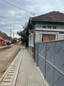 a house with a blue gate next to a street at CASA LUCIAN in Cîrţişoara