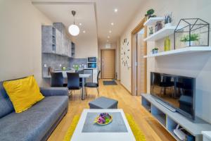uma sala de estar com um sofá e uma mesa em Luxury Kalman Centar Apartman em Zlatibor