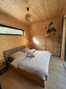 1 dormitorio con 1 cama en una habitación de madera en Woodland, en Kamieńczyk