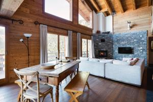 un soggiorno con un divano e un tavolo di Authentic Swiss Spa Chalet Nesoya Jacuzzi Sauna a Riddes