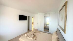 a white living room with a couch and a mirror at Ocean Mirror Apartment in Praia