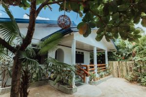 a house with a palm tree in front of it at Casa Ella in General Luna