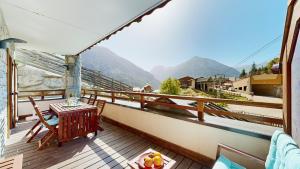 a balcony with a table and a view of mountains at Elégant logement, Superbe vue in Champagny-en-Vanoise