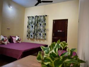 a room with a purple bed and a window at Anjunapalms GuestHouse in Anjuna
