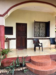 a room with a door and a chair and a table at Anjunapalms GuestHouse in Anjuna