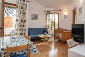 a living room with a blue couch and a table at Kornelija 2 in Podgora