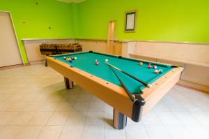 einen Billardtisch in einem Zimmer mit grünen Wänden in der Unterkunft JUFA Hotel Nördlingen in Nördlingen
