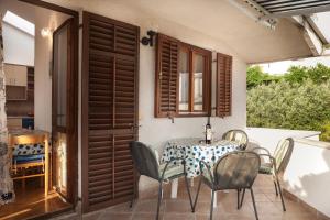 a dining room with a table and chairs on a balcony at Kornelija 2 in Podgora