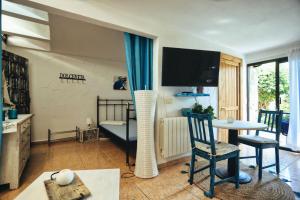 ein Wohnzimmer mit einem TV, einem Tisch und Stühlen in der Unterkunft Finca Vino Tinto 4 in Icod de los Vinos