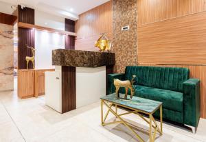 a lobby with a green couch and a table at Treebo Trend Lemon Wood Suites in Pune