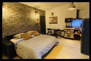 a bedroom with a bed and a brick wall at Studio Style Industriel avec Terrasse et Parking 