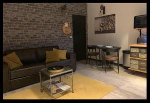 a living room with a black couch and a table at Studio Style Industriel avec Terrasse et Parking 