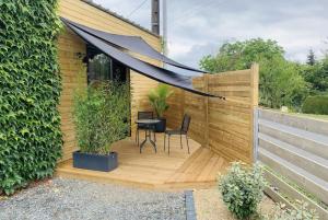 a wooden deck with a black canopy in a garden at Studio Style Industriel avec Terrasse et Parking 