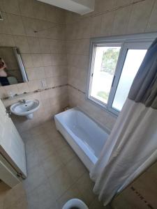 a bathroom with a tub and a sink and a window at Penthouse with rooftop terrace in Akanthou