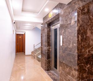 a hallway with a stone wall and a staircase at Treebo Trend Lemon Wood Suites in Pune