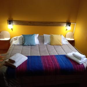 a large bed with pillows and towels on it at kukachalten in El Chalten