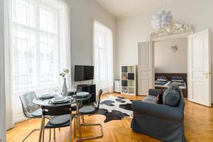 ein Wohnzimmer mit einem Sofa, einem Tisch und Stühlen in der Unterkunft Broadway Apartment Budapest in Budapest