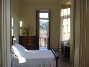 Schlafzimmer mit einem Bett und Blick auf einen Balkon in der Unterkunft Quinta dos Tres Rios in Parada de Gonta