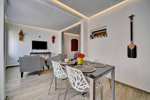 uma sala de jantar e sala de estar com mesa e cadeiras em Patio suite em Olhão