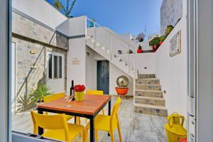 uma sala de jantar com uma mesa de madeira e cadeiras amarelas em Patio suite em Olhão