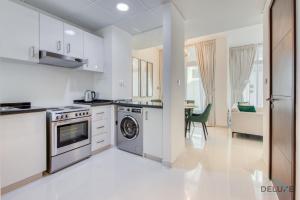 a kitchen with a stove and a dishwasher at Restful 3BR Townhouse at DAMAC Hills 2 Dubailand by Deluxe Holiday Homes in Dubai