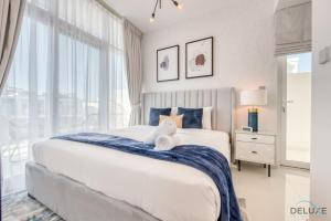 a bedroom with a large bed with a blue blanket at Restful 3BR Townhouse at DAMAC Hills 2 Dubailand by Deluxe Holiday Homes in Dubai