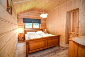 sypialnia z łóżkiem w drewnianym domku w obiekcie Wspólna Chata w mieście Białka Tatrzanska